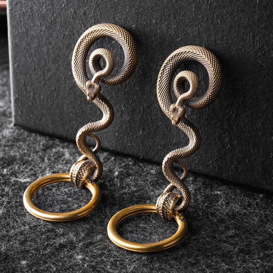 Two sizes of the brass coiled serpent keychain side by side