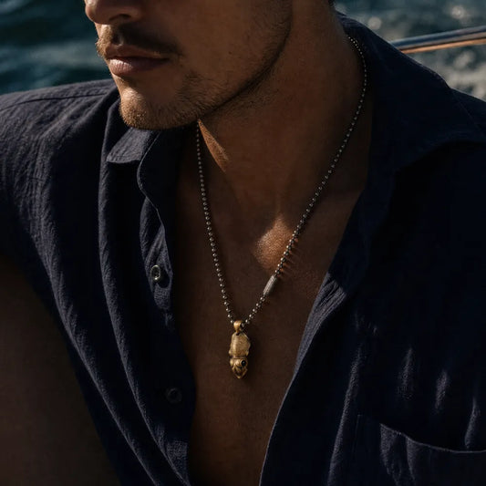 Cuttlefish box opener pendant worn on a ball chain by a man in a dark shirt.