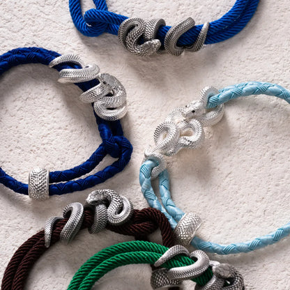 Black Mamba Rope Bracelet in 18K White Gold Plated White Bronze, held in hand with the complete rope bracelet visible.