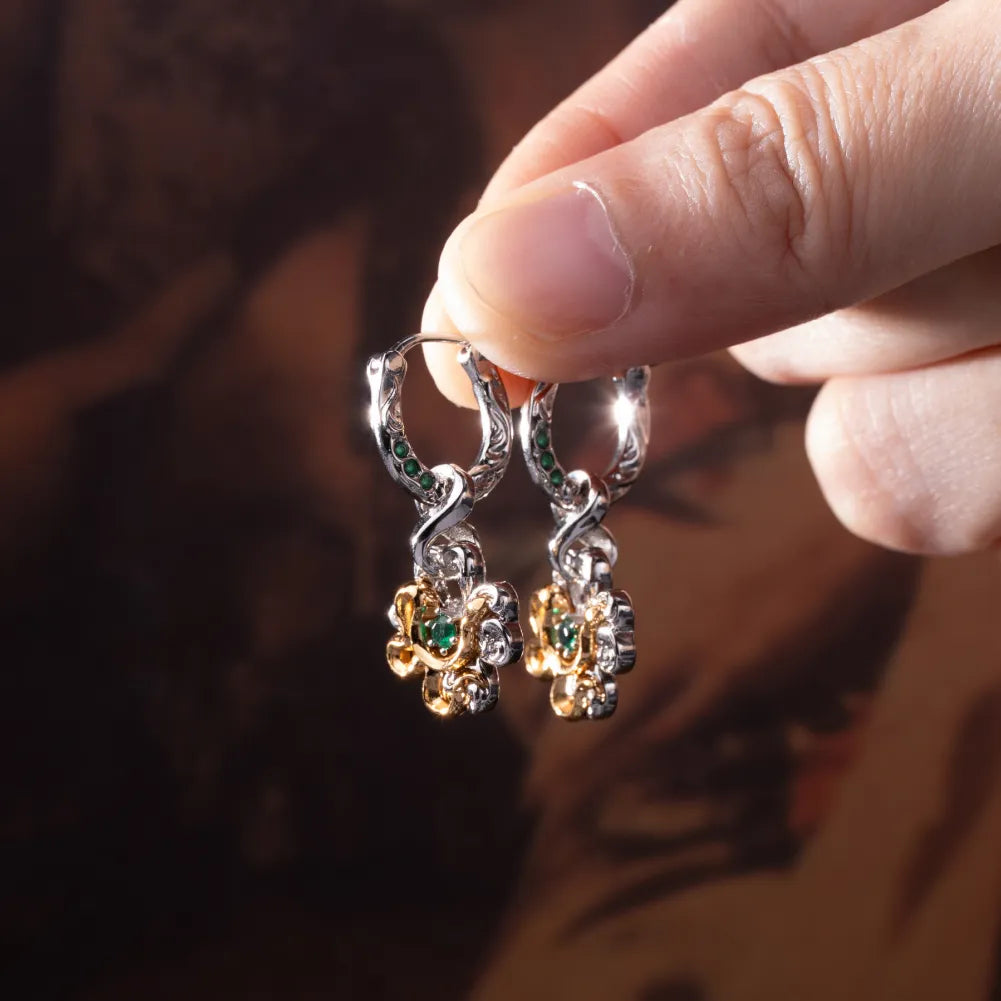 Pair of clover serpent earrings shown in hand