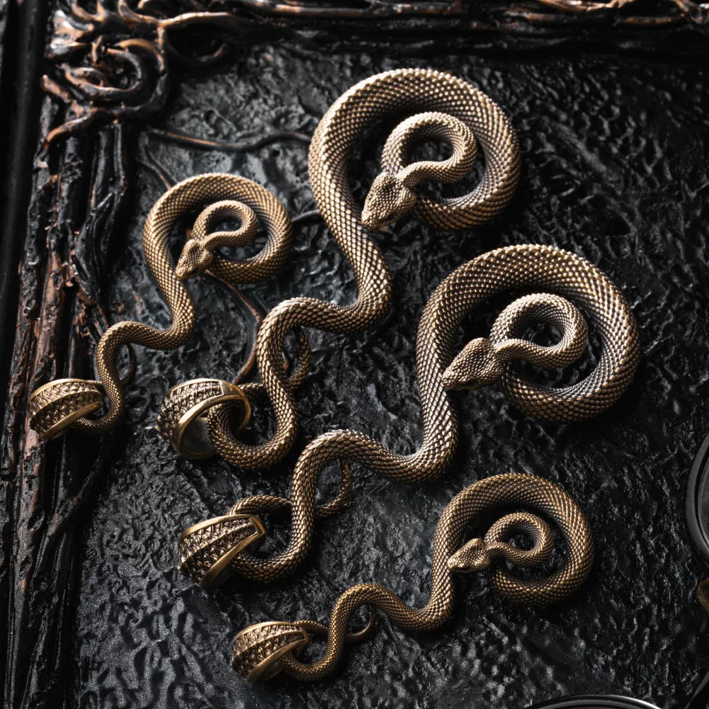 Family of brass coiled serpent keychains laid out together