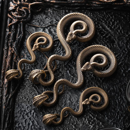 Family of brass coiled serpent keychains laid out together