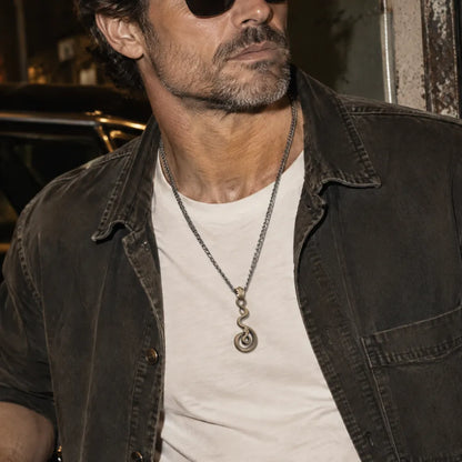 Man wearing the coiled serpent pendant with a white tee and sunglasses