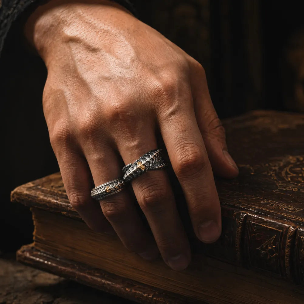 Dragon Scale Ring 2.0 styled on a man's hand resting on a vintage book