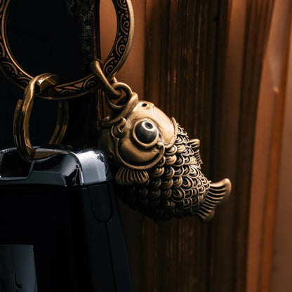 Koi fidget pendant attached to a leather handbag