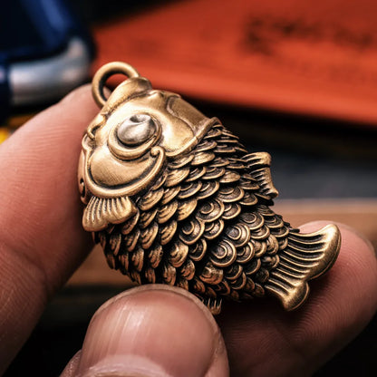 Koi fidget pendant held in hand for scale
