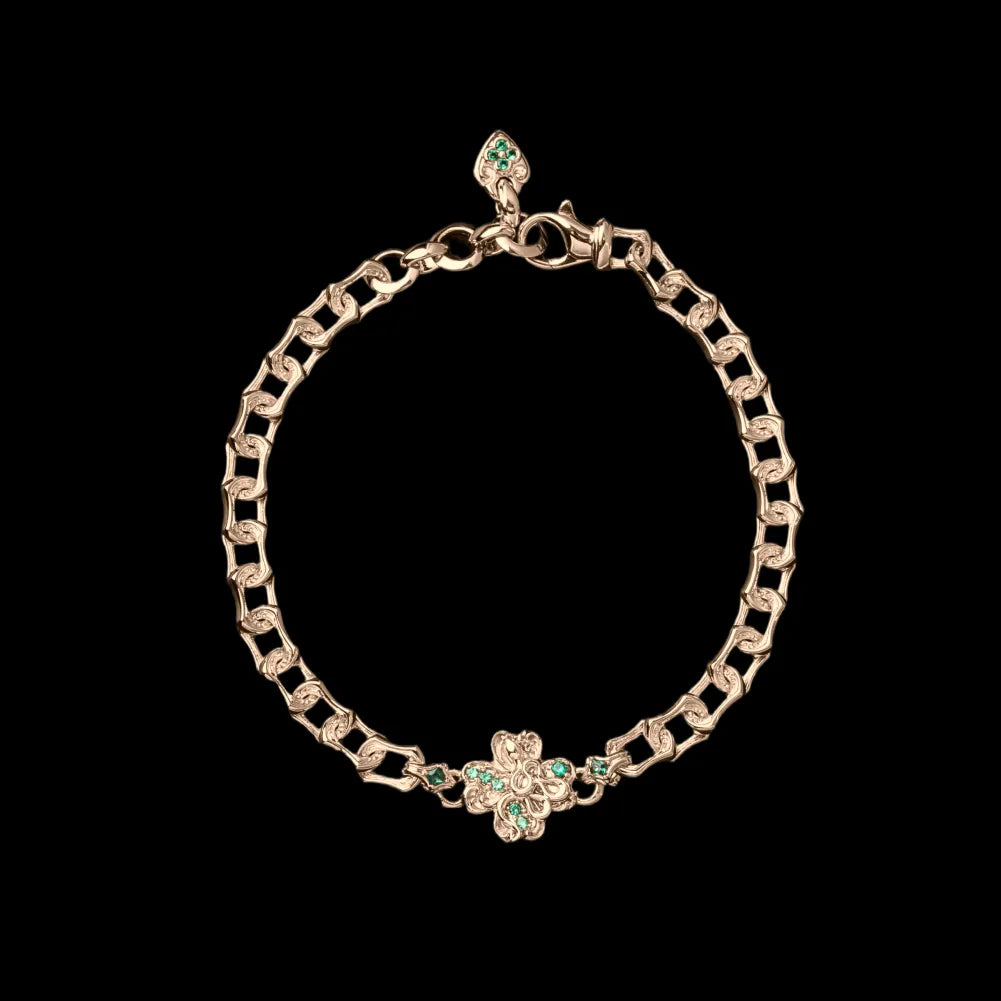 Gold-tone Lucky Clover Snake Bracelet with green clover details on a black background