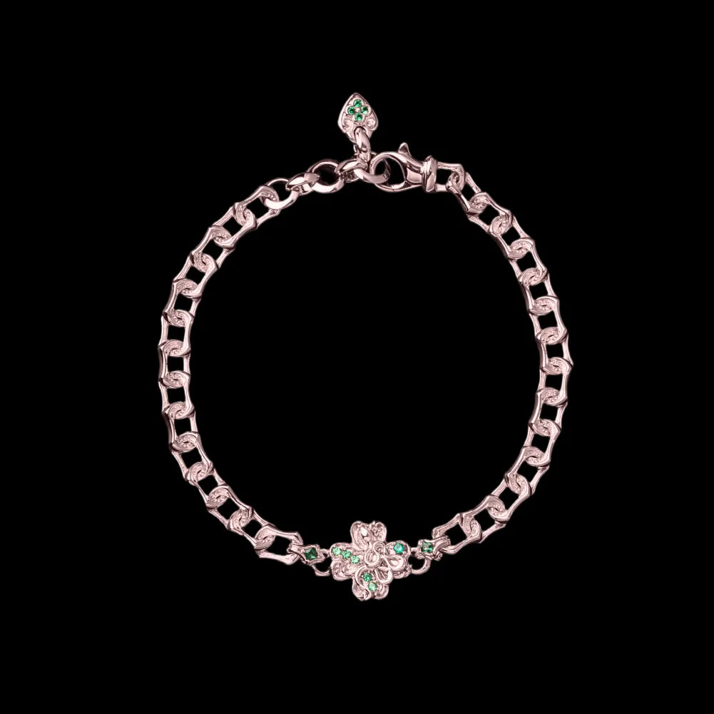Rose-gold-tone Lucky Clover Snake Bracelet with green clover details on a black background