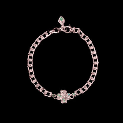 Rose-gold-tone Lucky Clover Snake Bracelet with green clover details on a black background