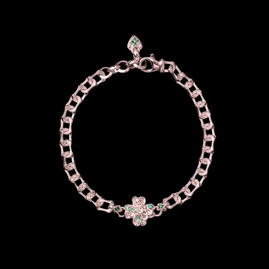 Rose-gold-tone Lucky Clover Snake Bracelet with green clover details on a black background