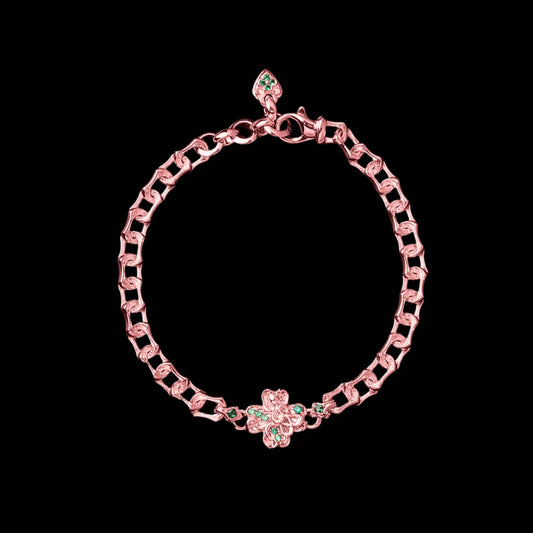 Rose-gold-tone Lucky Clover Snake Bracelet with green clover details on a black background