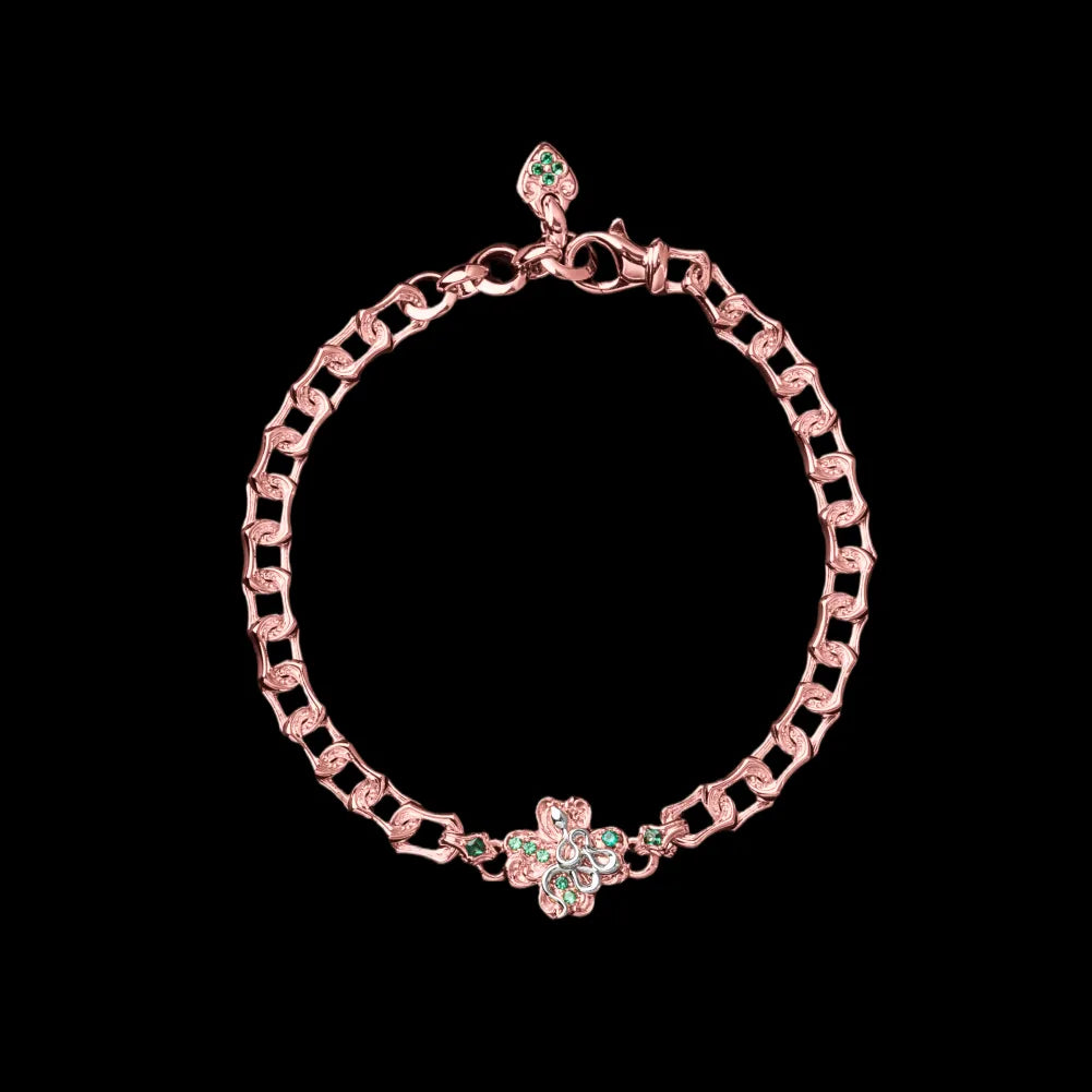 Rose-gold-tone and light-tone Lucky Clover Snake Bracelet with green clover details on a black background