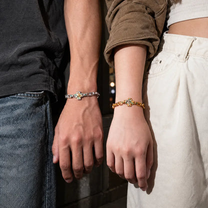 Two people wearing the gold-tone and silver-tone Lucky Clover Snake Bracelets