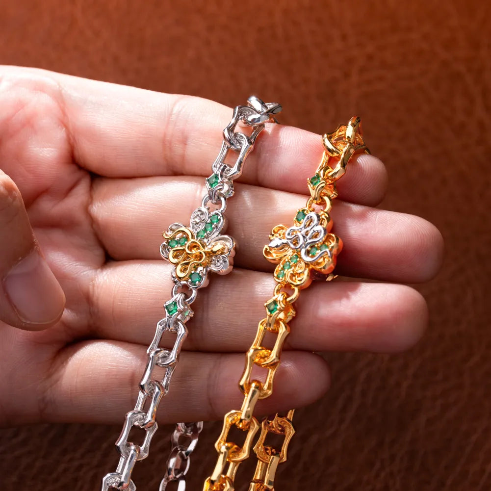 Hand holding the gold-tone and silver-tone Lucky Clover Snake Bracelets