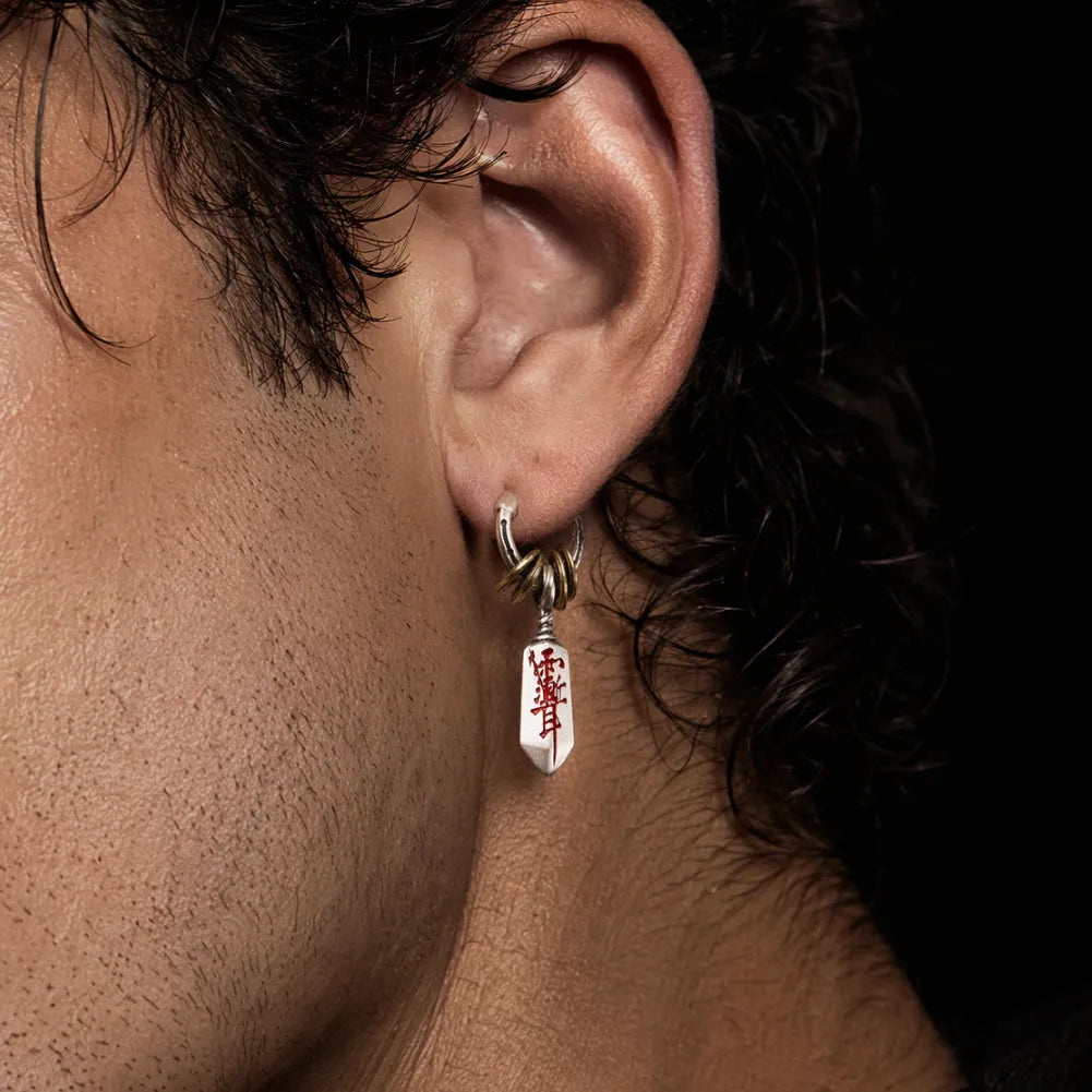 Man wearing a Masterblade talisman earring in a side view