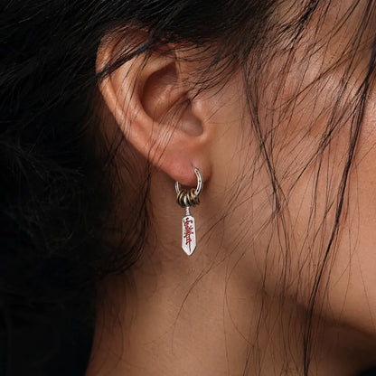 Woman wearing a Masterblade talisman earring in a close-up view