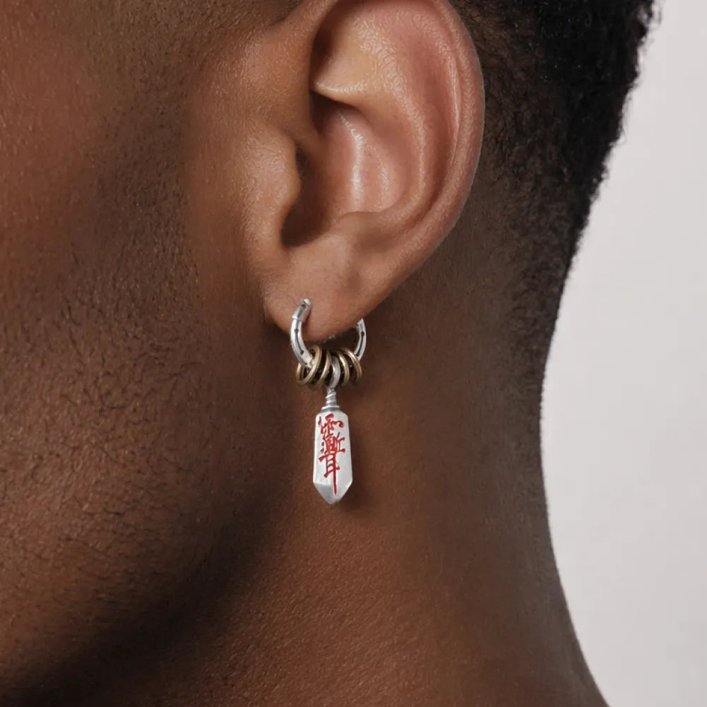 Close-up of a Masterblade talisman earring worn on the ear
