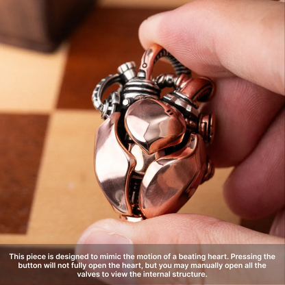 Hand holding the Copper & White Bronze Mechanical Heart Pendant to show its polished metal details