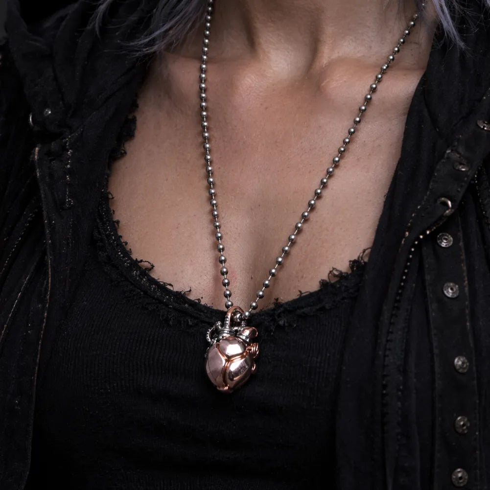 Close-up view of the Copper & White Bronze Mechanical Heart Pendant worn on a necklace