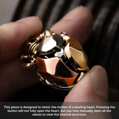 Hand holding the White Bronze & Brass & Copper Mechanical Heart Pendant to show its polished metal details