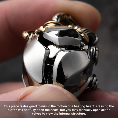 Hand holding the White Bronze & Brass Mechanical Heart Pendant to show its polished metal details