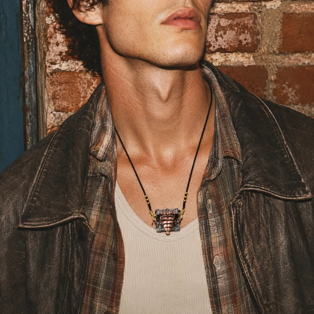 White bronze and copper Mimicling Chest Pendant worn with a leather jacket