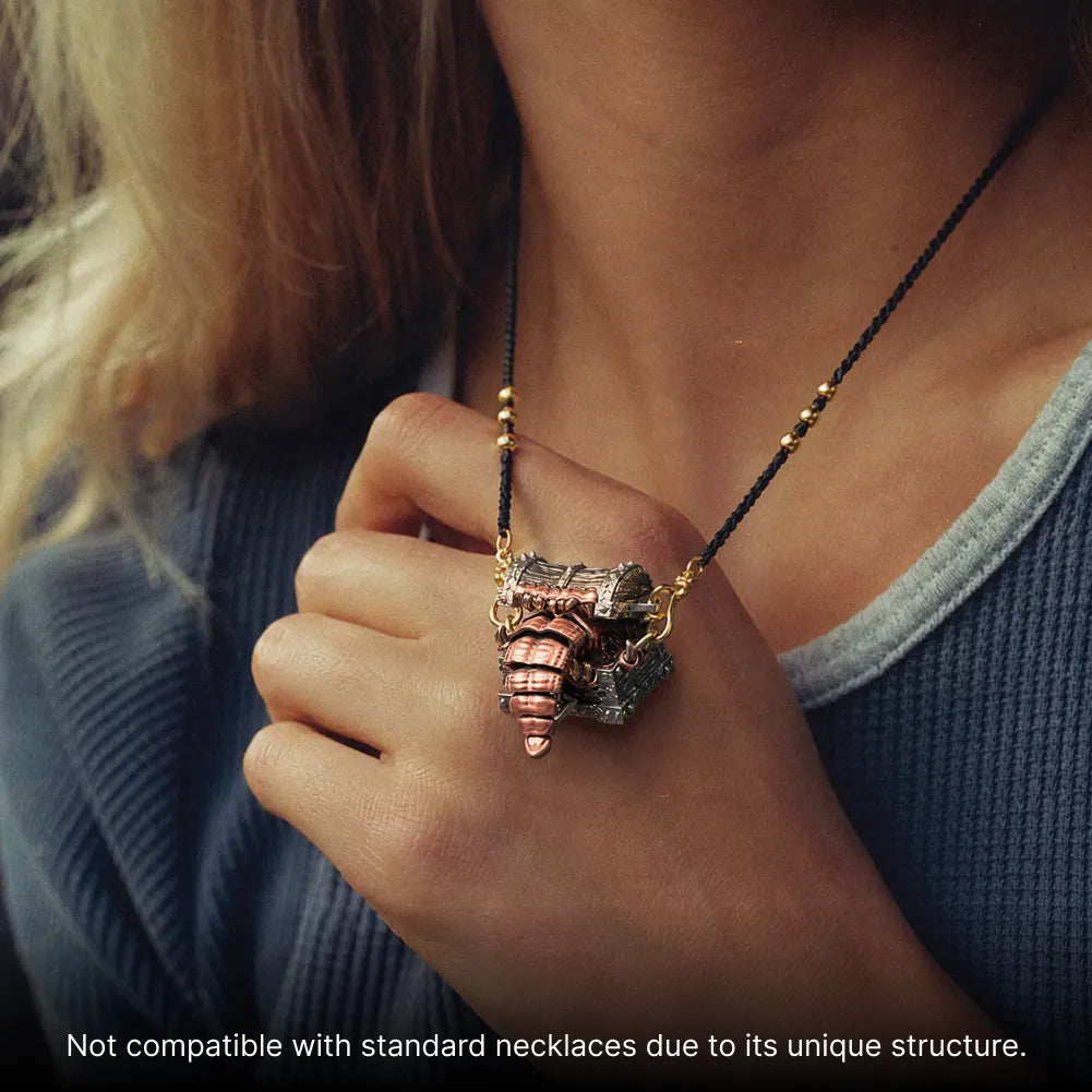 Mimicling Chest Pendant necklace held against a blue top