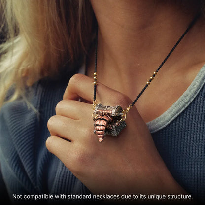Mimicling Chest Pendant necklace held against a blue top