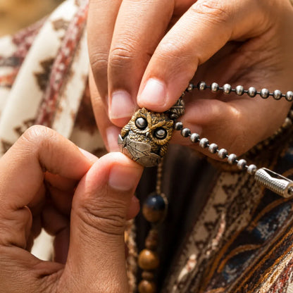 Owl fidget pendant held in hand showing the moving eye mechanism