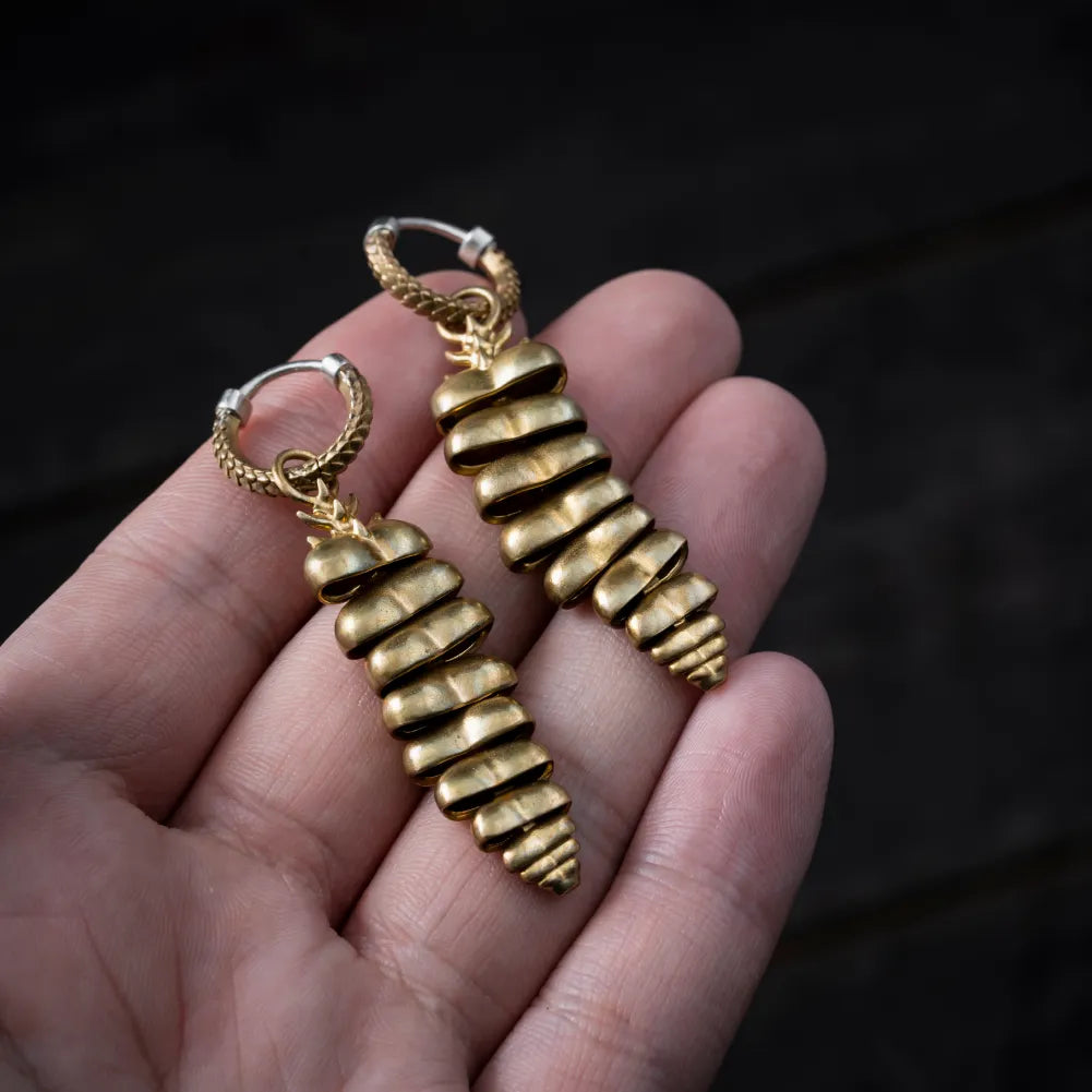 Pair of Rattlesnake Tail earrings held in hand