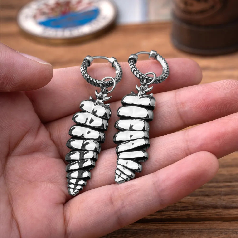 Rattlesnake Tail Earrings in White Bronze with Oxidized Sterling Silver Pins, pair held in hand with the articulated tail segments visible.