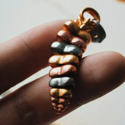 Tricolor rattlesnake tail pendant held in hand showing articulated segments
