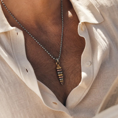 Tricolor rattlesnake tail pendant close up on a white shirt