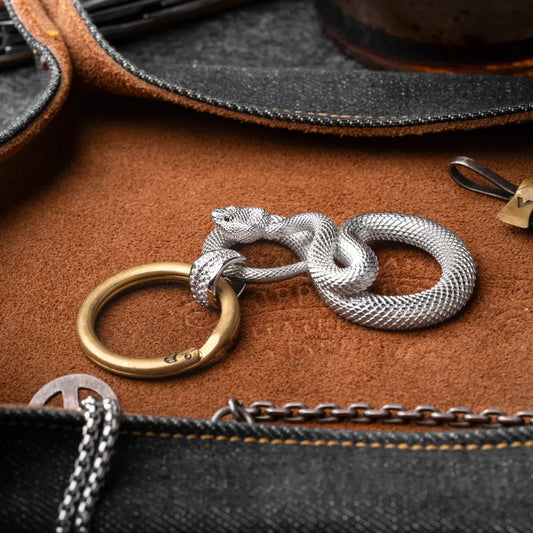 Snake Keychain in 18K White Gold Plated White Bronze, shown with keys in a leather-surface flat lay.