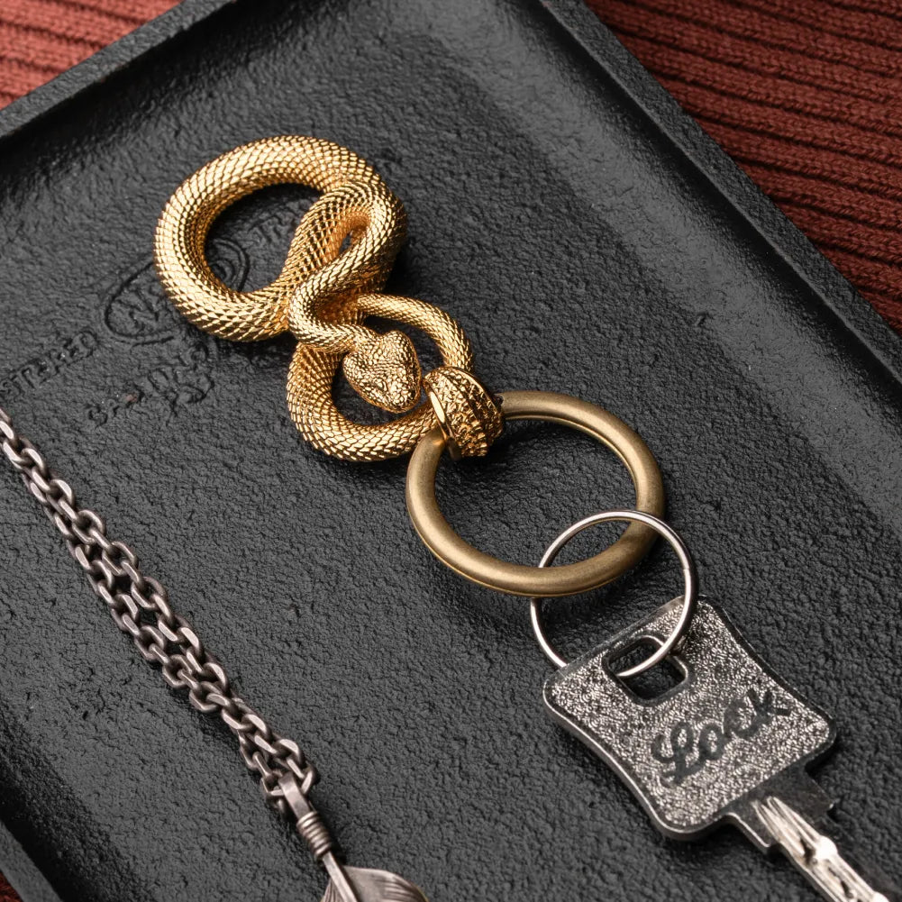 Snake Keychain in 24K Gold Plated Brass, shown with keys in a leather-surface flat lay.