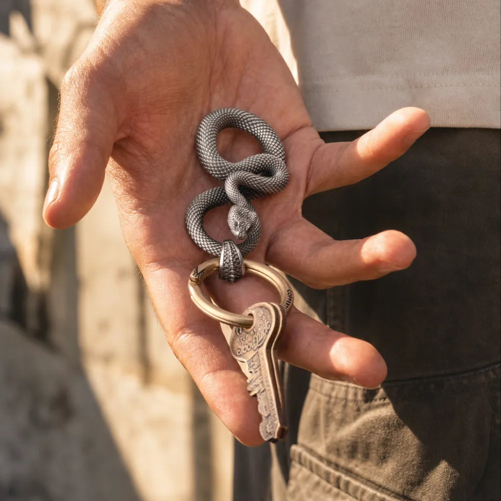 Snake Keychain in White Bronze, held in hand with keys in an everyday-carry lifestyle view.