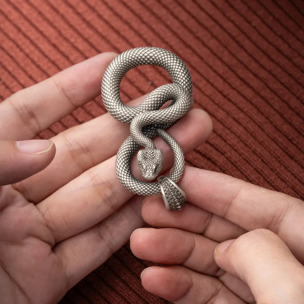 Snake Keychain in White Bronze, held close up with the snake head and loop construction visible.