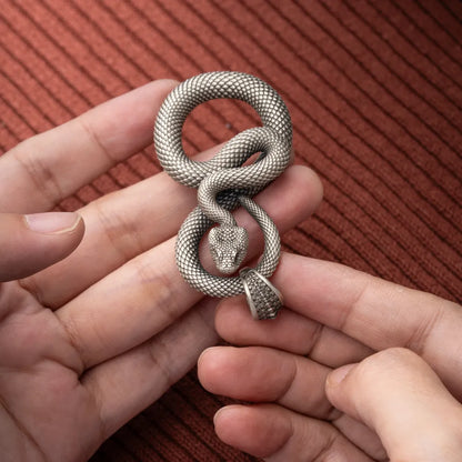 Snake Keychain in White Bronze, held close up with the snake head and loop construction visible.