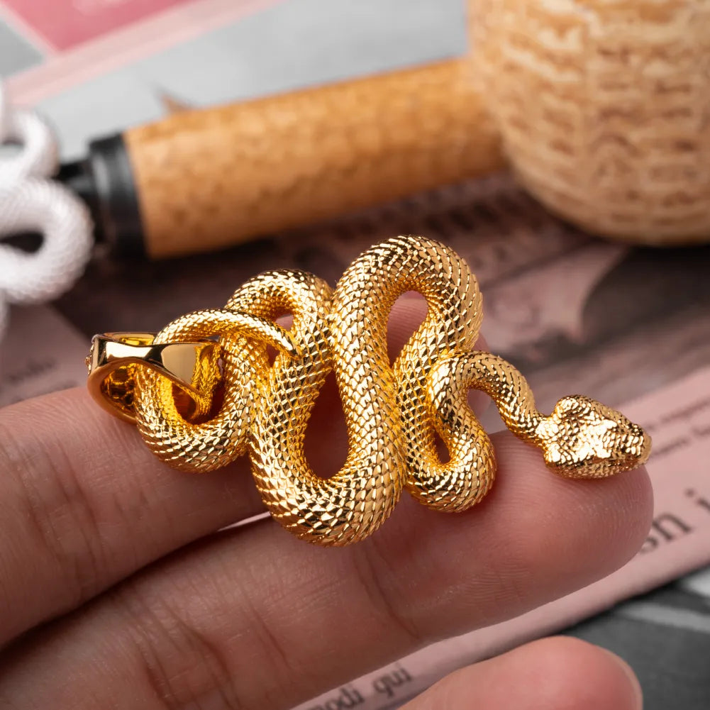 Snake Pendant in 24K Gold Plated Brass, held in hand with the coiled body and head visible.