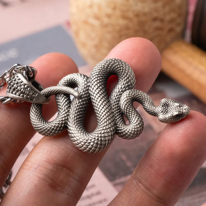 Snake Pendant in White Bronze, held in hand with the coiled body and head visible.
