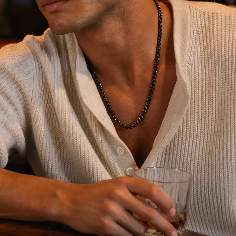 Black stainless steel Cuban chain necklace worn with a light shirt
