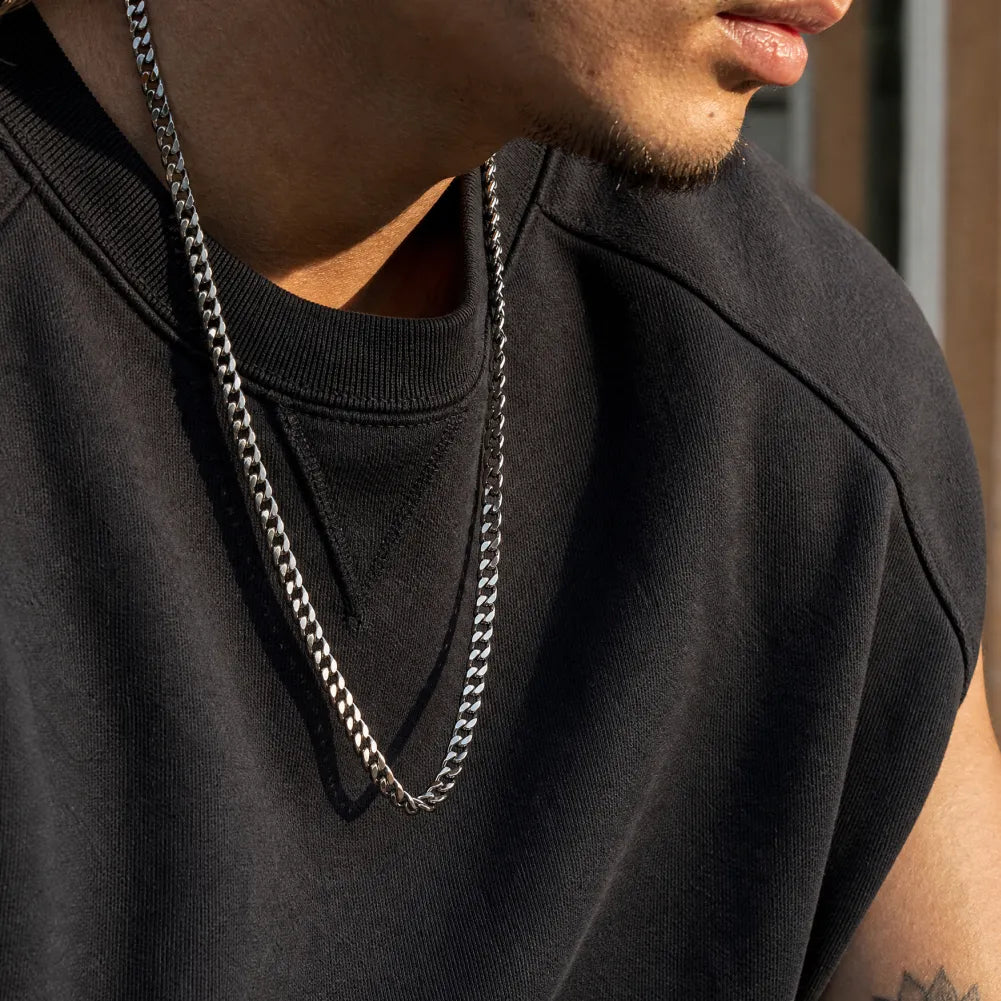 Original-color stainless steel Cuban chain necklace worn with a black shirt