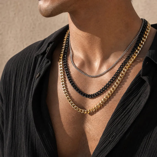 Original-color, black and gold-color Cuban chain necklaces layered on a model