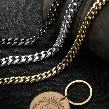 Close-up of black, original-color and gold-color stainless steel Cuban chain links