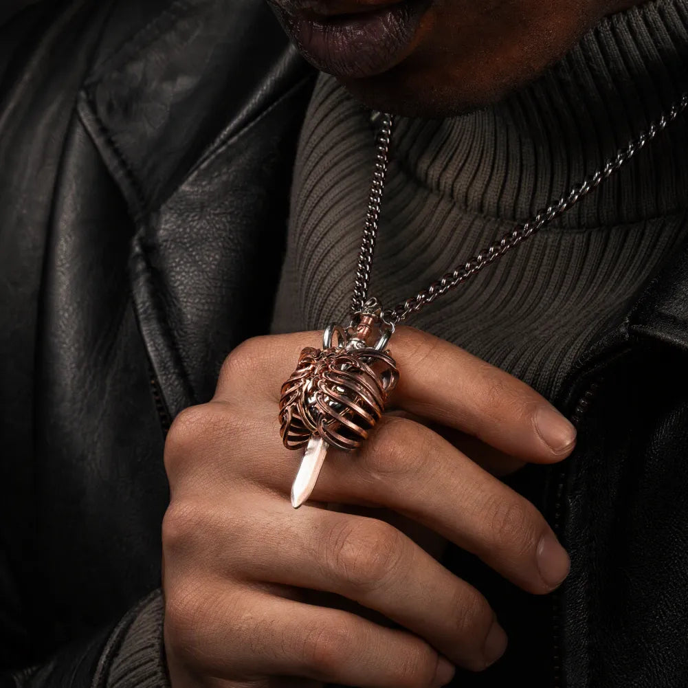 Copper and white bronze Beating Heart Pendant held against a dark sweater