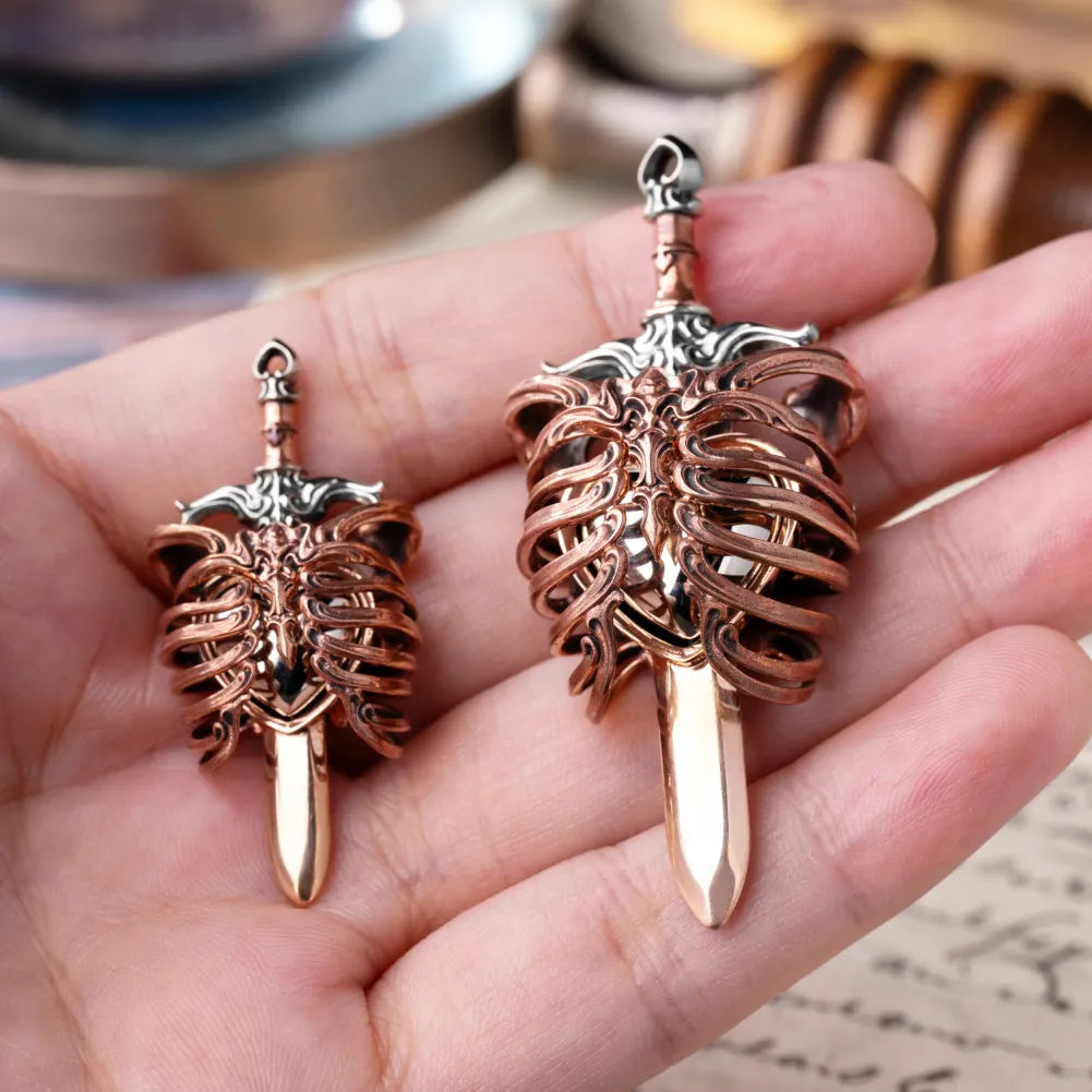 Small and large copper and white bronze Beating Heart Pendants shown in hand
