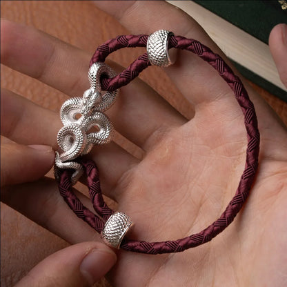 Tree Boa Rope Bracelet in 18K White Gold Plated White Bronze, held in hand with the complete rope bracelet visible.